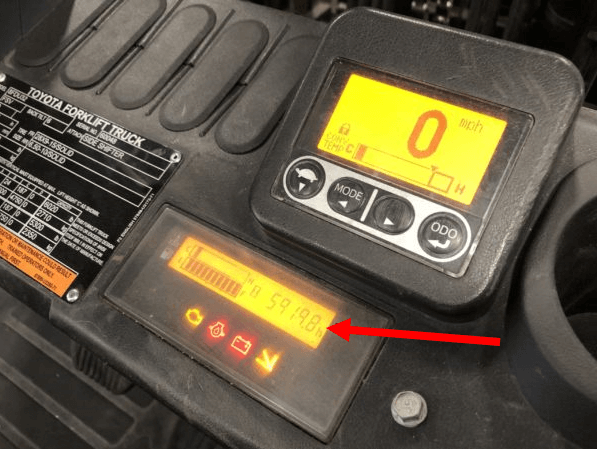 A Toyota internal combustion forklift with the hour meter location marked on the dashboard