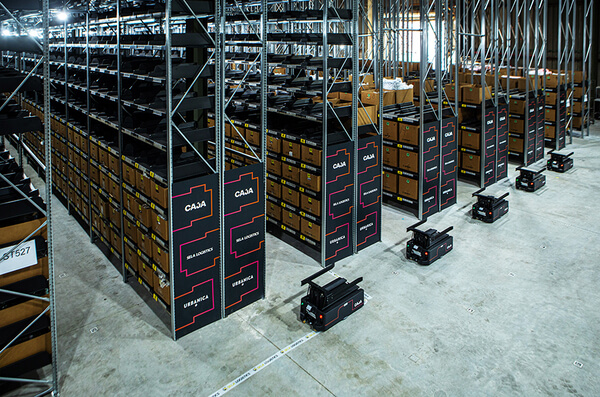 amrs-in-front-of-pallet-racking Empty AMRs lined up at the end of pallet racking