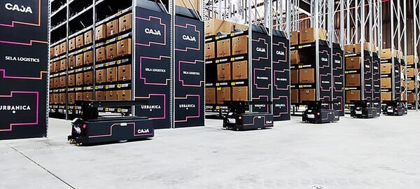 amrs-lined-up-in-front-of-racking A line of AMRs traveling past pallet racking