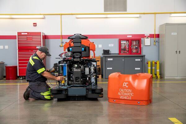 A technician working on a Toyota AGV tow tractor