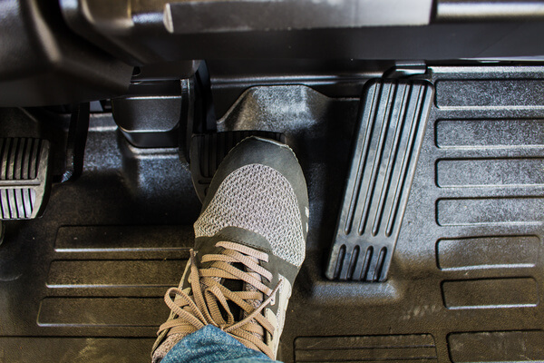 A forklift operator pressing on the brake pedal