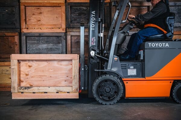 Toyota electric forklift lifting a wooden crate