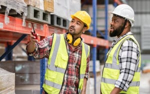 Male workers inspecting, checking shipping stocks in storage, warehouse or factory for delivery.