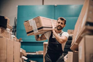 Hardworking employee holding box on the shoulder