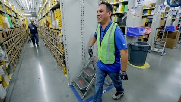 A worker walking through the aisle of a fulfillment center