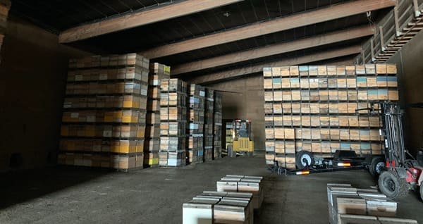 A forklift inside of a climate-controlled warehouse storing bee hives