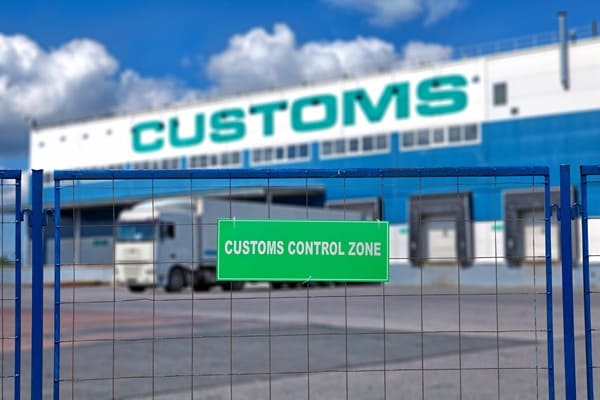 The outside of a customs warehouse loading dock with a semi-truck parked