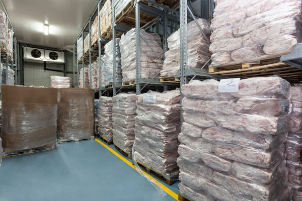 A freezer storage room containing palletized meat products