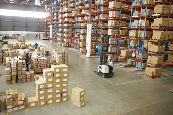 public-warehouse A warehouse with a reach truck driving through it