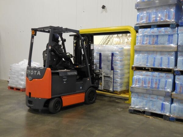 A Toyota electric forklift handling a pallet of ice in a cold storage warehouse
