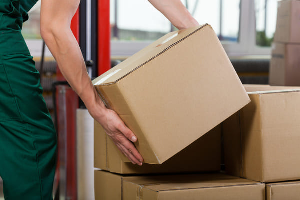 A worker picking up a cardboard box