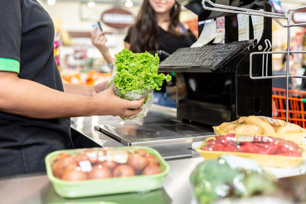 A grocery store worker scanning produce using an RF scanner