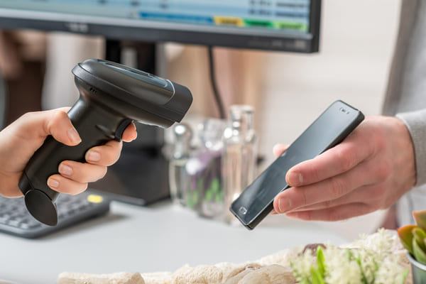 A worker using an RF scanner to scan a smartphone screen