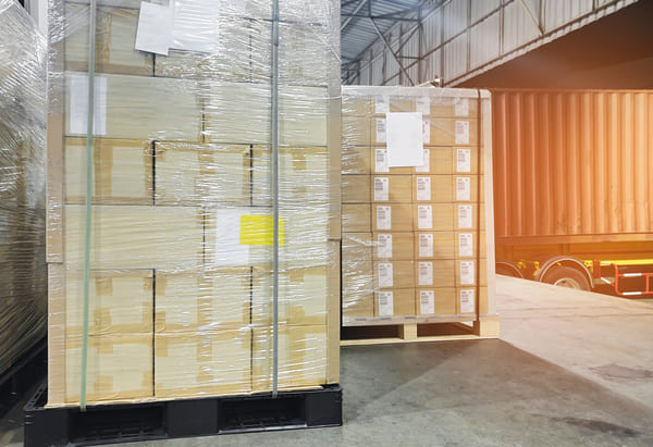 A stack of boxes arranged in an interlocking pattern on a pallet in a shipping dock