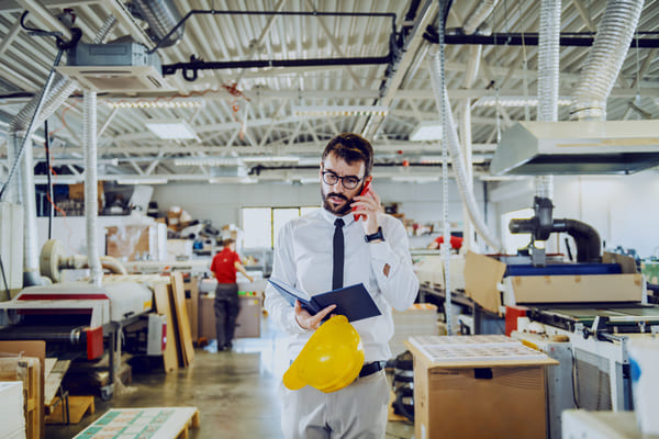 A supervisor walking through a production line while talking on a phone