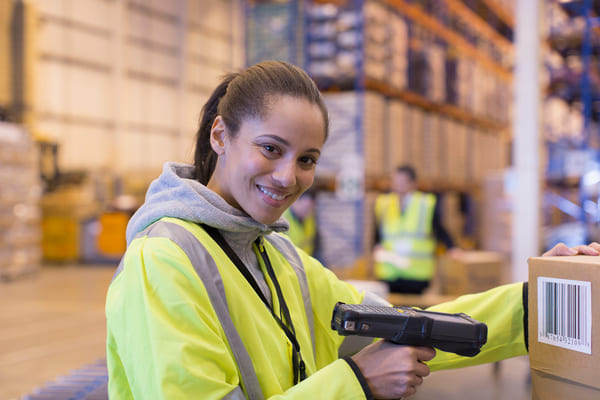 A warehouse worker using a mobile computer to scan a barcode on a box