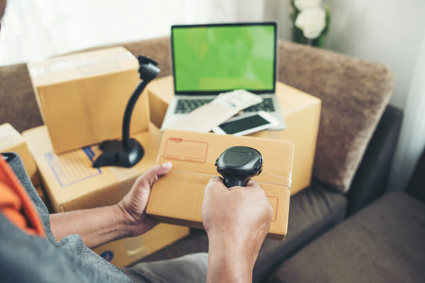 A person using an RF scanner to scan a box in their living room