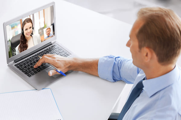 A pair of suppliers having a virtual meeting on a laptop