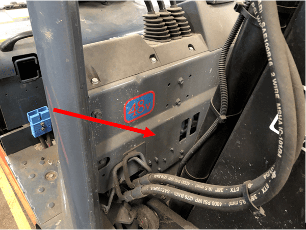 A serial number location pointed out on the frame of a Toyota electric forklift