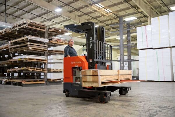 A worker driving a Toyota straddle lift truck