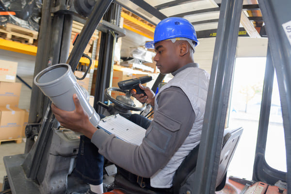 A forklift operator using an RF scanner to scan an item in a loading dock