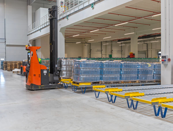 A reach truck handling pallets in a distribution area