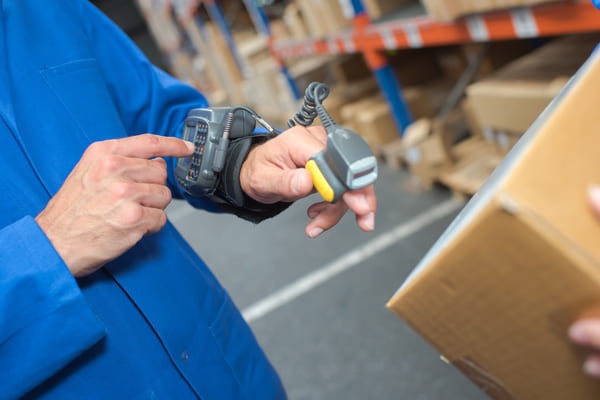 A warehouse worker pressing buttons on a wearable RF scanner
