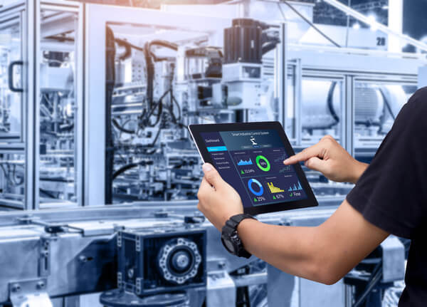 An engineer pressing the screen of a tablet in a manufacturing facility