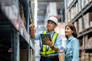 Two workers managing a warehouse with a tablet