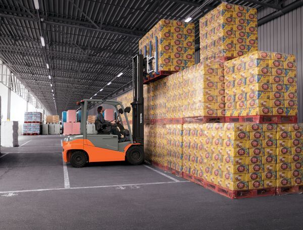 A Toyota electric forklift stacking pallets in warehouse