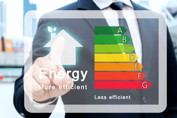 A person in a business suit pointing at an energy efficiency sign