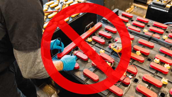 A forklift battery technician testing a forklift battery terminal