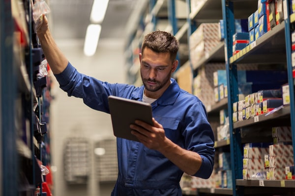 A mechanic searching a parts shelf for an item