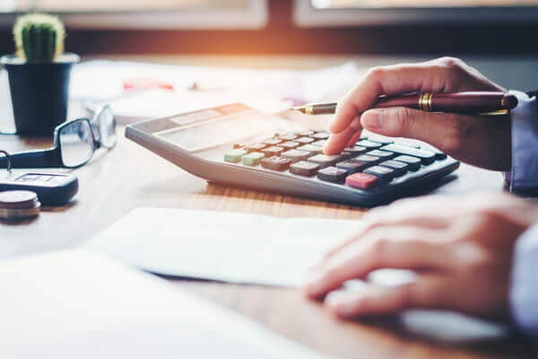 An office worker typing on a calculator at a desk