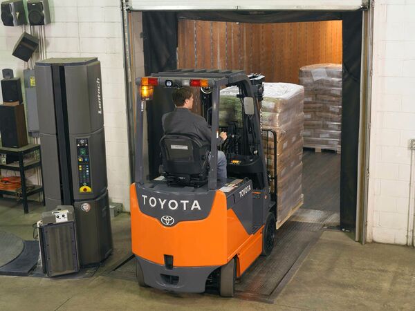 A Toyota electric forklift entering a semi-trailer with a pallet of goods