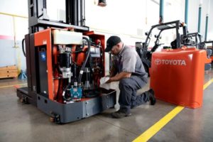 A Toyota forklift technician performing maintenance on a Toyota order picker