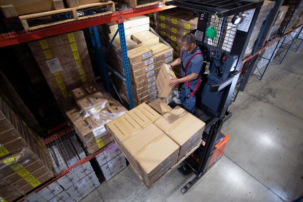 A warehouse worker picking boxes with a Toyota order picker