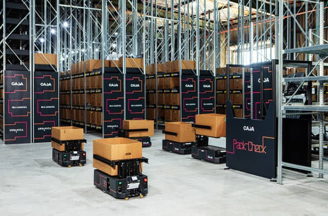 A autonomous mobile robot (AMR) carrying cardboard boxes in a warehouse