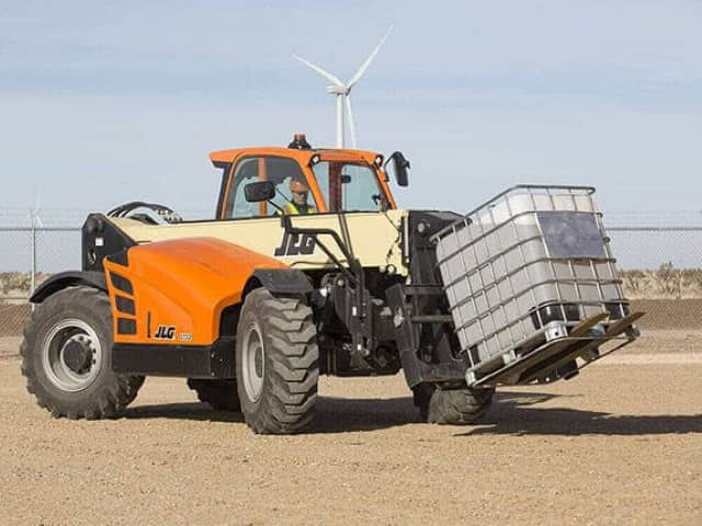 A JLG 1732 high-capacity telehandler at a construction site handling a bulk liquid tank