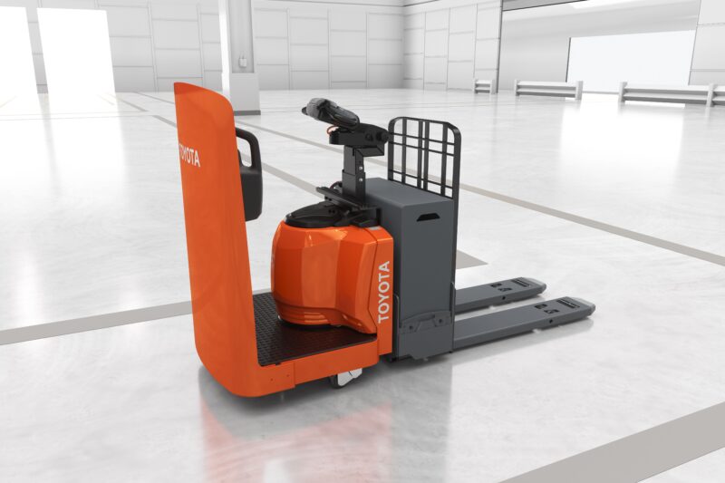 A Toyota side-entry end rider pallet jack as viewed from a side angle in a simulated warehouse