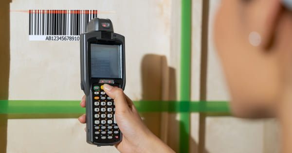 Worker using an RF scanner to scan a barcode on a cardboard box