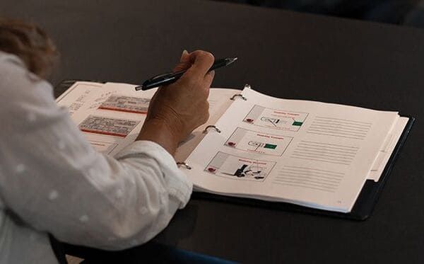 A forklift trainee with a training book on a desk