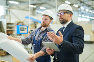 business man visiting factory and talking to engineer