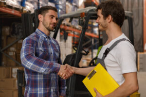 Two men shaking hands in a warehouse