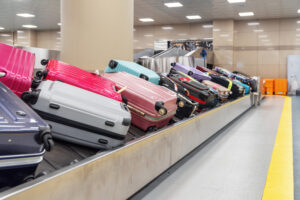 Bright pink suitcases on luggage conveyor belt in airport