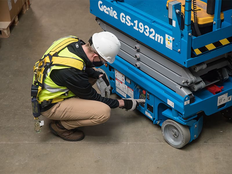 Equipment tech working on a genie scissor lift