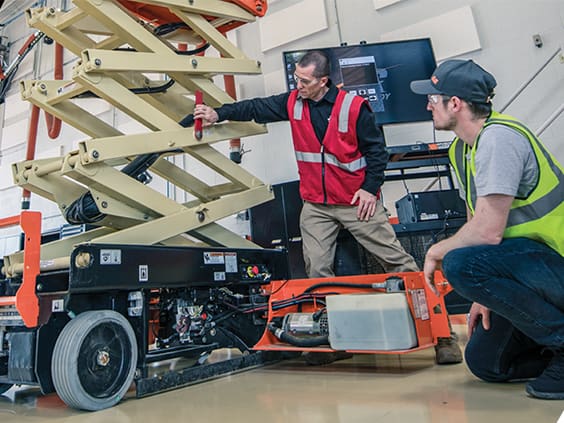 Equipment techs working on a jlg scissor lift